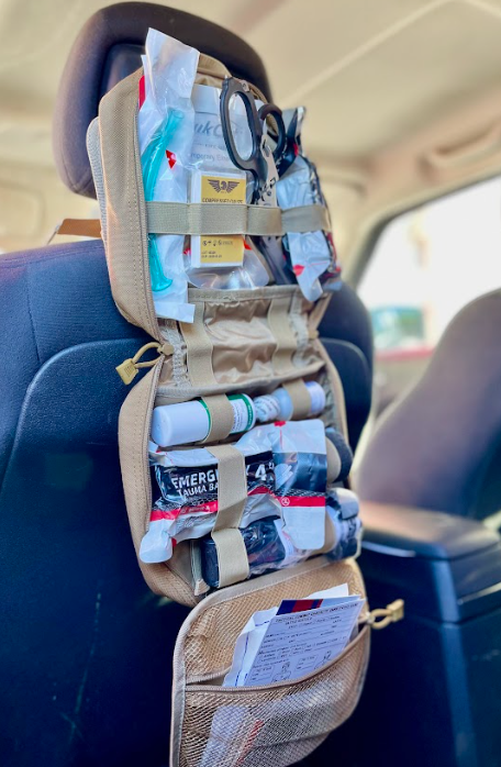 tan Police2Bag opened in vehicle showing fold-out compartments and organized trauma supplies