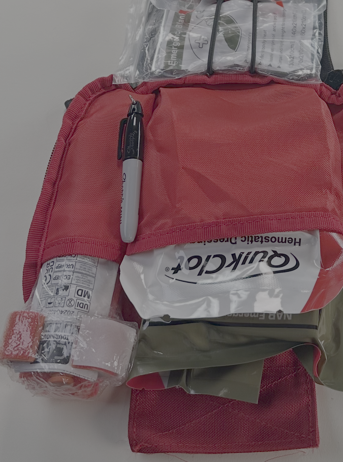 BePrepared2Treat Red IFAK QuikClot Kit opened to show emergency trauma supplies and QuikClot hemostatic dressing